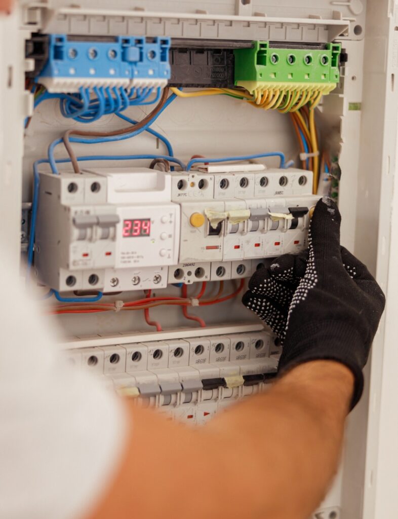 A man is working on an electrical panel.
