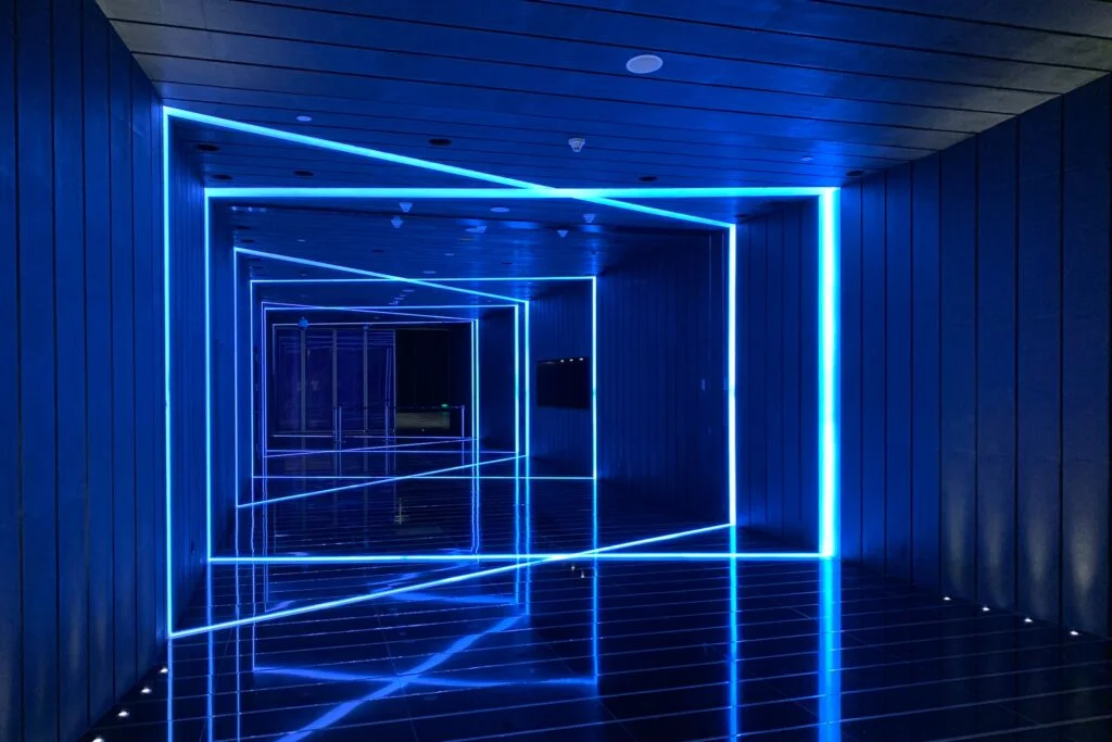 A hallway with blue LED lights flickering against the backdrop of a warm wooden floor.