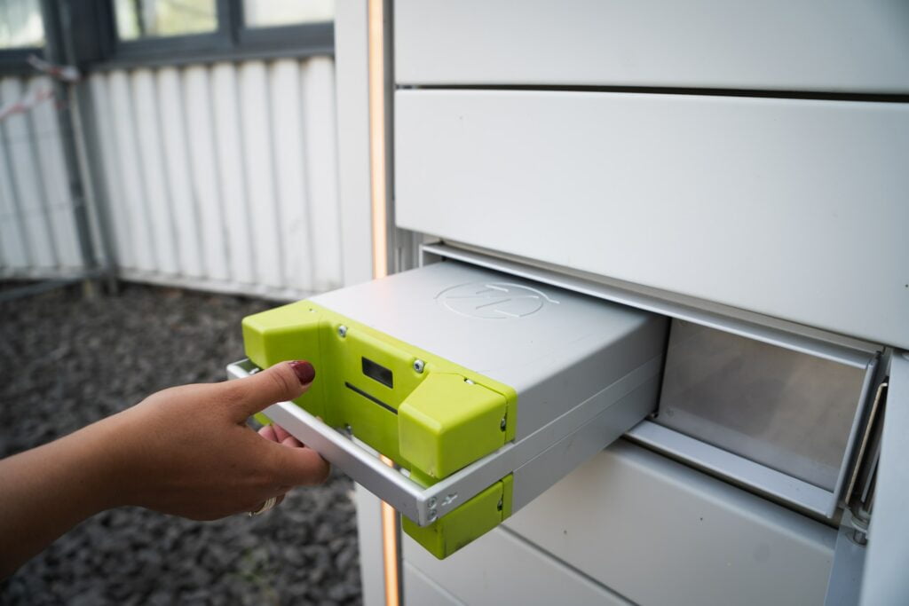 A person inserting a device into a mailbox to unlock the potential of solar battery storage in Australia's bright future.