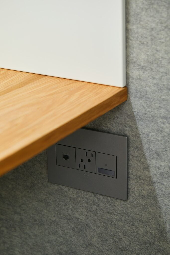 A wooden desk with a power outlet featuring Understanding the Different Types of Electrical Outlets.